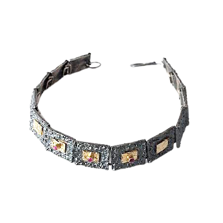 Bracelet articulé argent patiné, composé de 13 éléments rectangulaires, ornés de 5 rectangles or jaune et 3 rubis sertis.