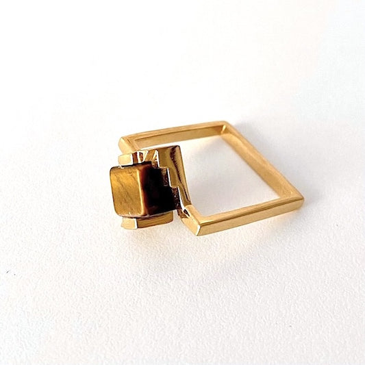 Bague solitaire en vermeil anneau fin carré. Son design audacieux intègre un cube en Oeil de tigre enchâssé entre deux éléments en forme d'escalier.