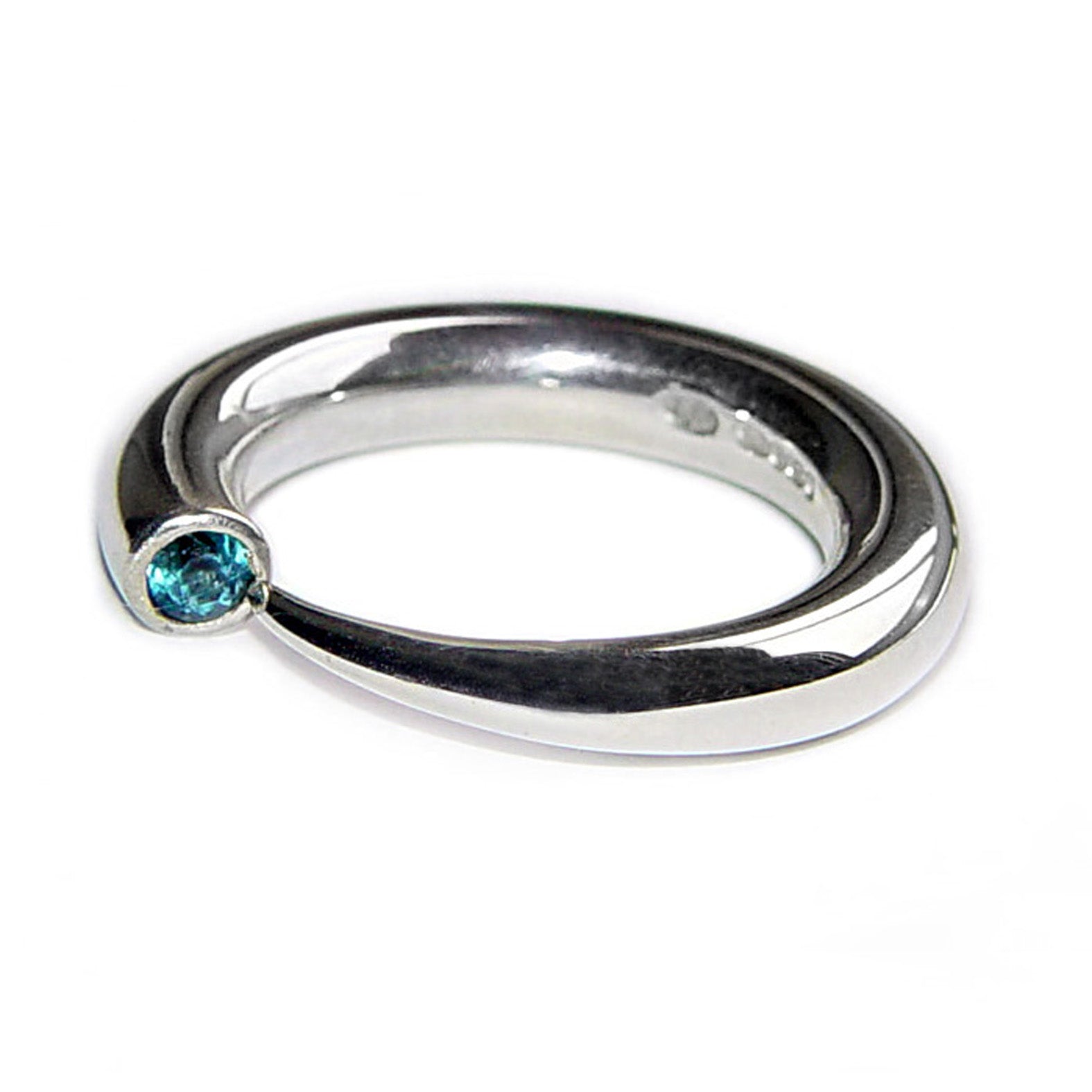 Bague effilée en argent poli se caractérise par un anneau arrondi confortable qui se rétrécit en pointe sur une topaze bleue.