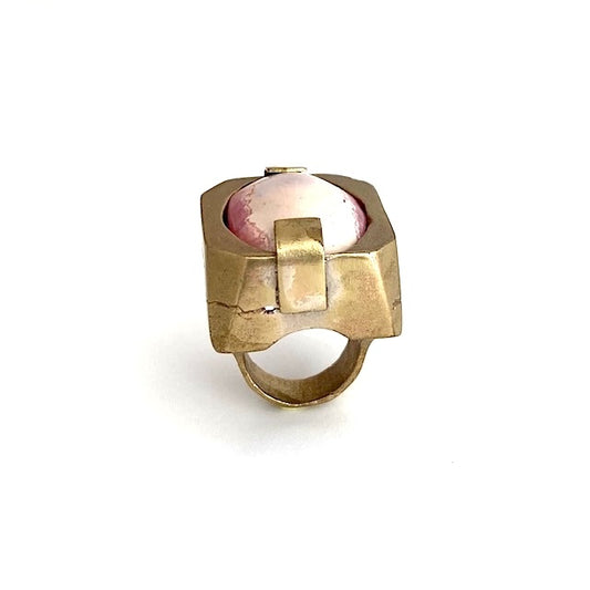 Bague sculpturale rectangulaire en bronze entaillé sur les longueurs. Au centre en cabochon, une Rhodochrosite rose tendre et fuchsia habille le bijou.