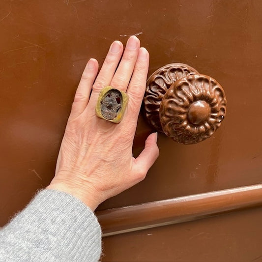 Grande bague rectangulaire en bronze patiné à la feuille d'or et plaque ovale de métal rouillé. Bijou porté, décor porte marron.
