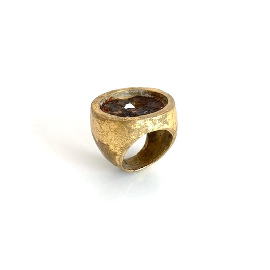 Large chevalière ronde en bronze patiné avec de la feuille d'or. Au centre une plaque ronde en fer rouillé et usé habille le bijou.