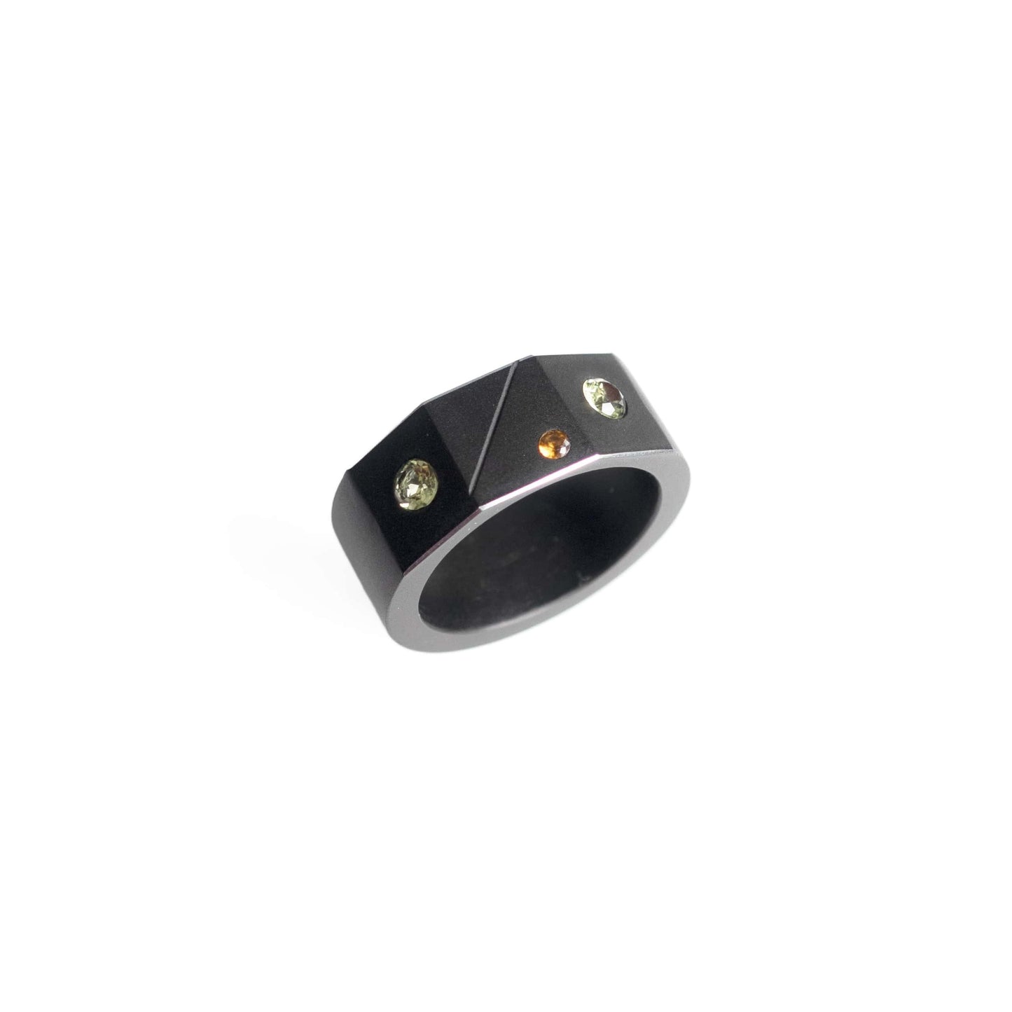 Bague forme chevalière en aluminium anodisé noir orné de deux péridots et d'un grenat hessonite. Vue de profil.