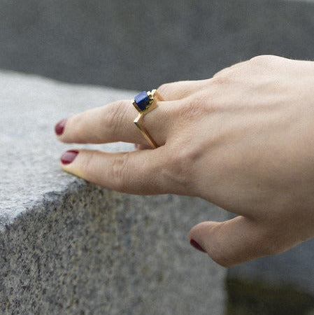 Bague solitaire, anneau fin et carré en vermeil sertie un cube de lapis-lazuli imbriqué entre deux éléments en formes d'escalier. 