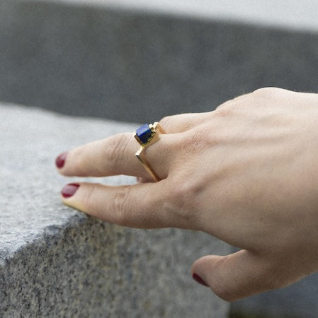 Bague solitaire, anneau fin et carré en vermeil sertie un cube de lapis-lazuli imbriqué entre deux éléments en formes d'escalier.