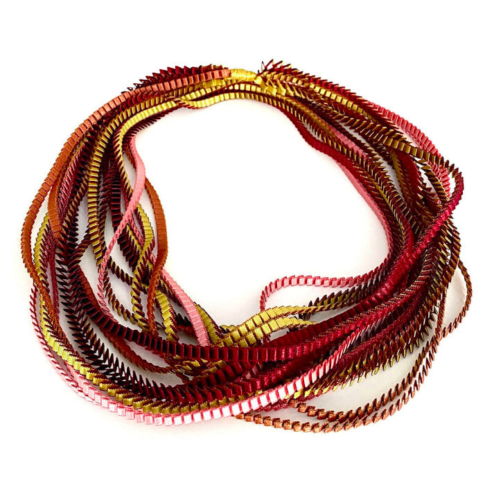 Long collier coloré composé de huit bandes de satin plissé bordeaux,marron,gold,vieux rose, pèche reliées les unes aux autres par un lien de coton jaune 