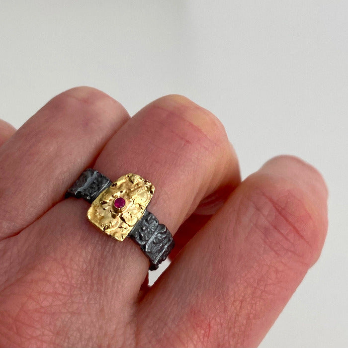 Bague argent patiné, texturé orné d'un rectangle irrégulier recouvert d'or jaune 18k avec un rubis au centre