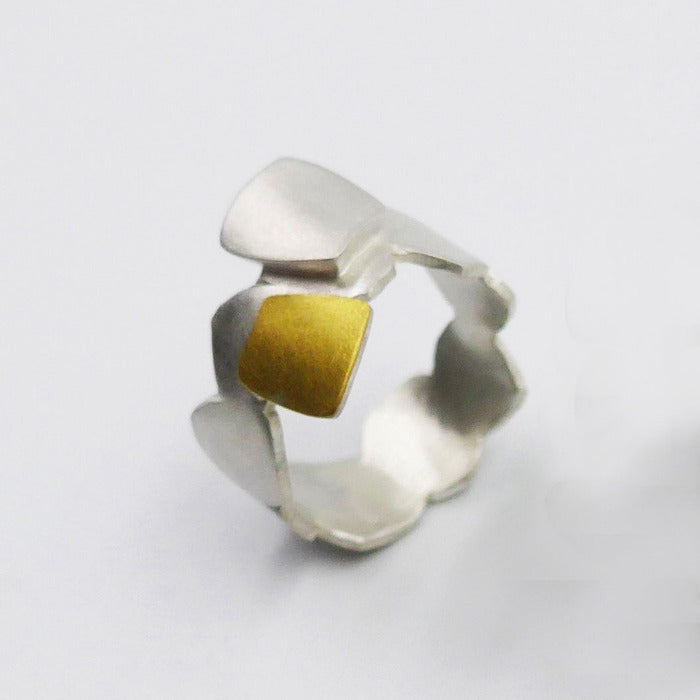 Bague géométrique en argent brossé formée de carrés irréguliers et d'un carré en or jaune