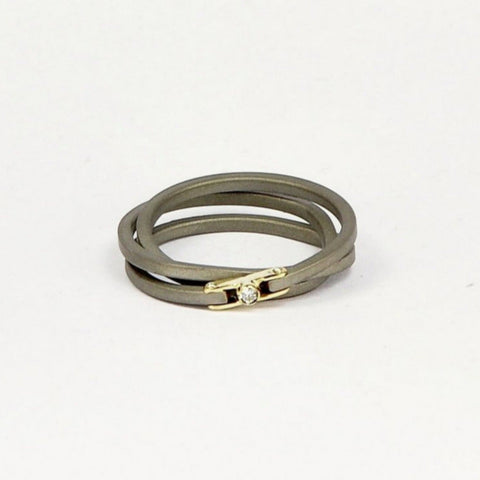 Bague 3 anneaux fils d'acier inoxydable carré, maintenus par un fermoir en or jaune serti d'un zircon.