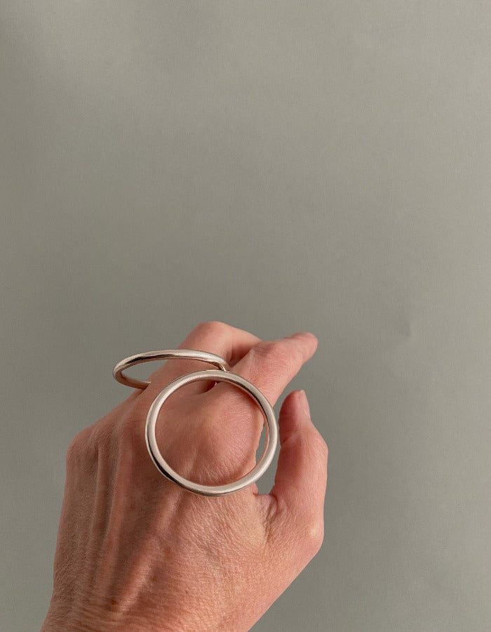 Bague géométrique en argent composée d'un cercle et d'un ovale relié par un anneau central à porter sur différents doigts