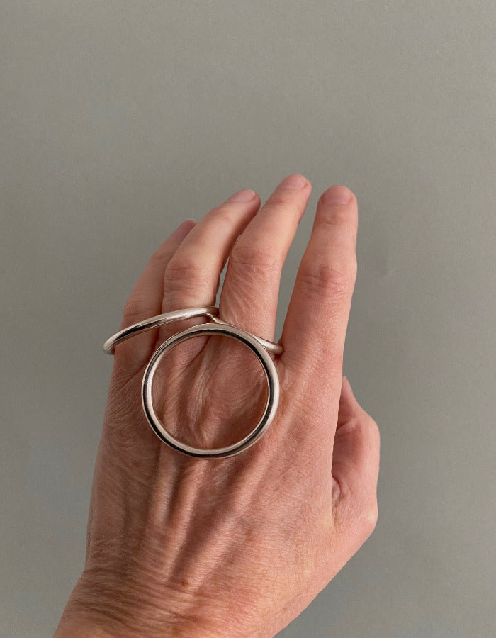 Bague géométrique en argent composée d'un cercle et d'un ovale relié par un anneau central à porter sur différents doigts