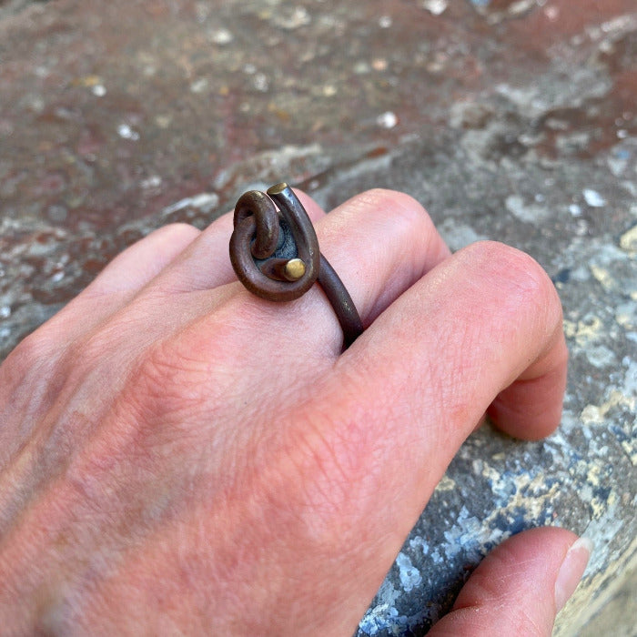 Bague avec noeud sur le dessus en titane forgé, patine effet bois, reflets dorées. pièce 2019