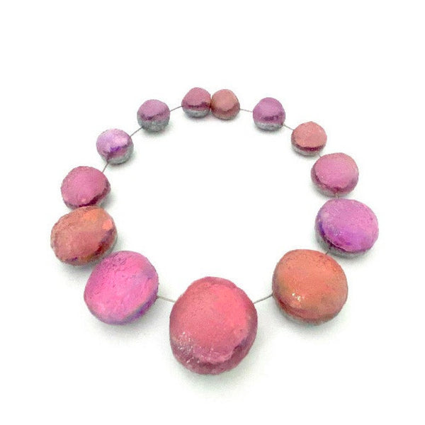 Collier composé de 13 sphères de résine rose irisée.
